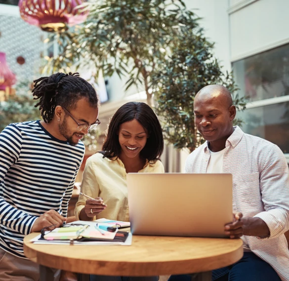 Team collaborating around a laptop